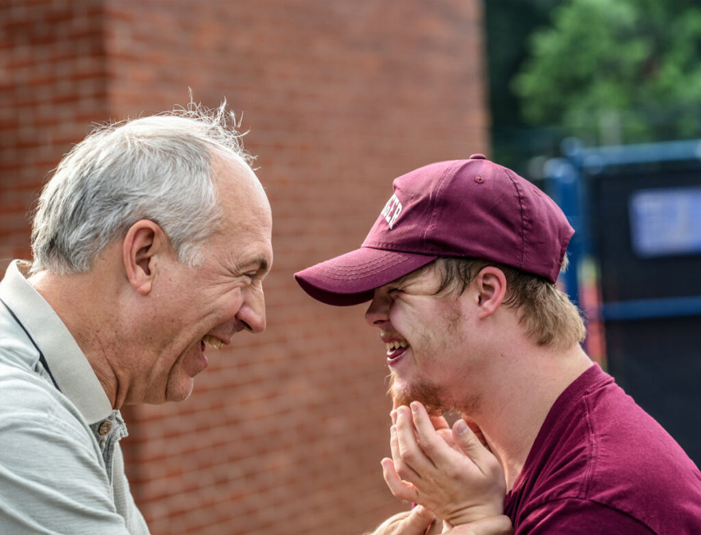 Two men smiling and embracing