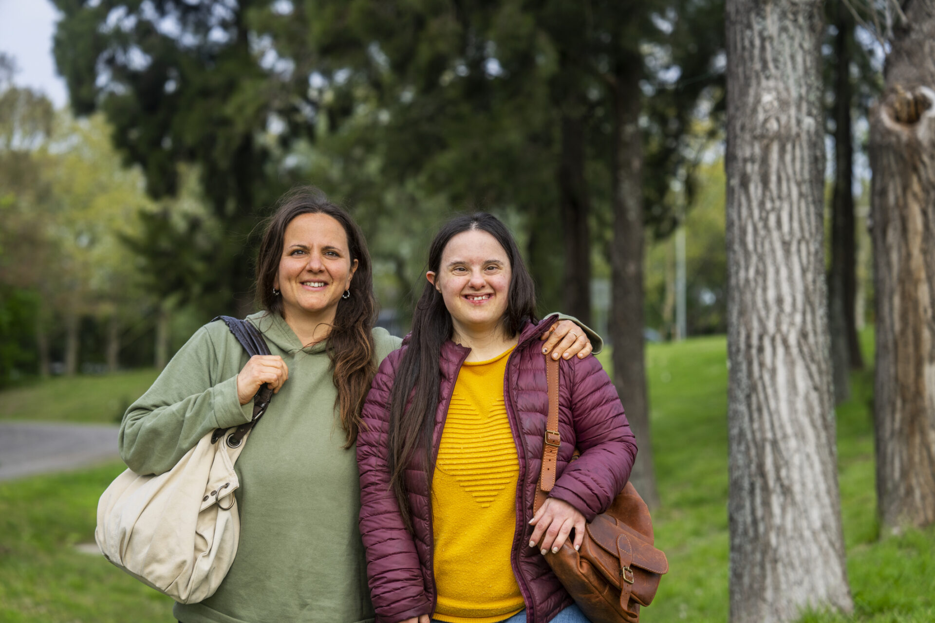 Mother and daughter with down syndrome taking a walk at park Female mentor and a young lady with down syndrome taking a walk at park
