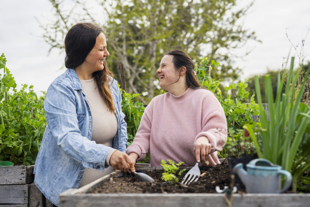 Young adult woman with down syndrome working on garden Young adult woman with down syndrome working on garden