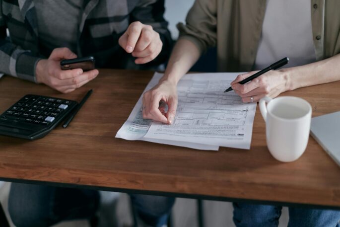 assistance with paying bills for people with intellectual disabilities Two people sitting at a table writing on a piece of paper