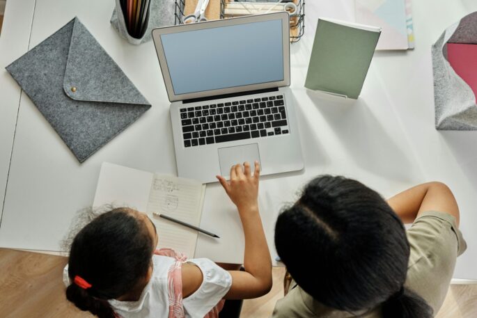 education support information for families of disabled people A young girl and a parent working on a laptop