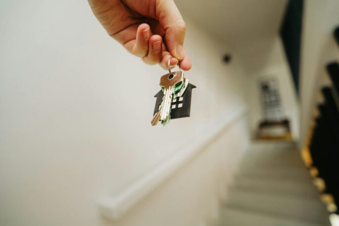 housing support and advocacy for disabled people in auckland A hand holding keys in front of a staircase
