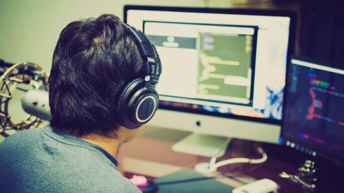job finding support for a man with autism auckland A person sitting at a desk working on a computer, wearing headphones